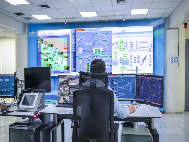 Operátor modern vezérlőteremben technológiai rendszereket felügyel
