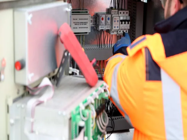 Mérnök ipari elektromos áramkört vizsgál közelről